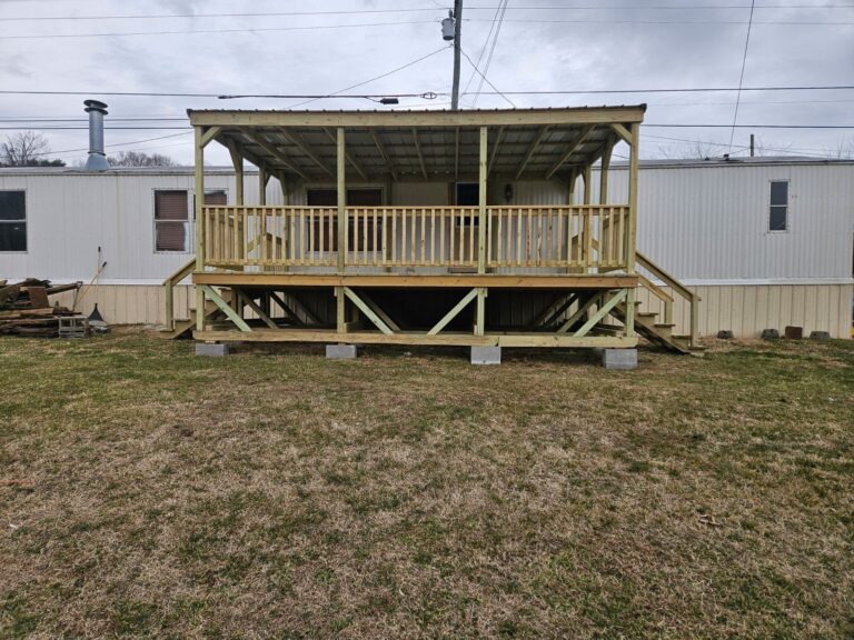 Side view of a 14x20 covered porch with wooden railings and steps leading to a mobile home in Morristown, Tennessee.
