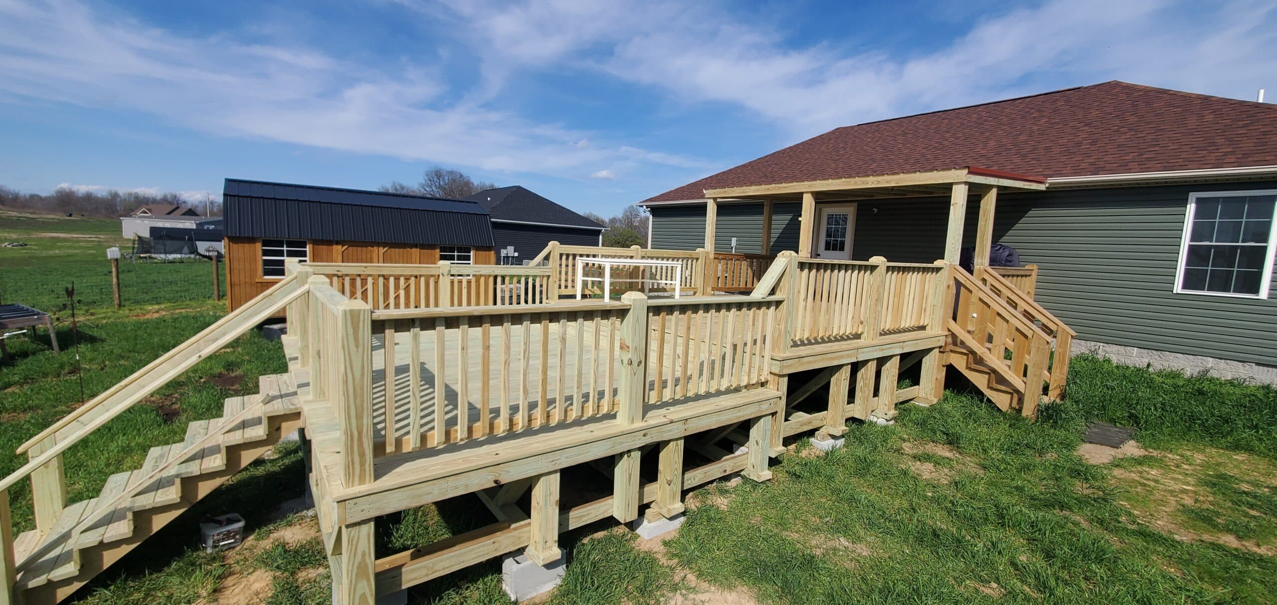 Close-up of a 24x16 elevated wooden deck with railing overlooking a grassy backyard in Westmoreland, Tennessee.