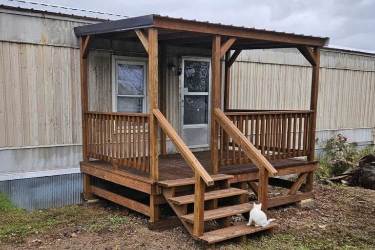 8x12 brown-stained wooden deck with stairs and a metal roof attached to a mobile home in Morgantown, Kentucky.