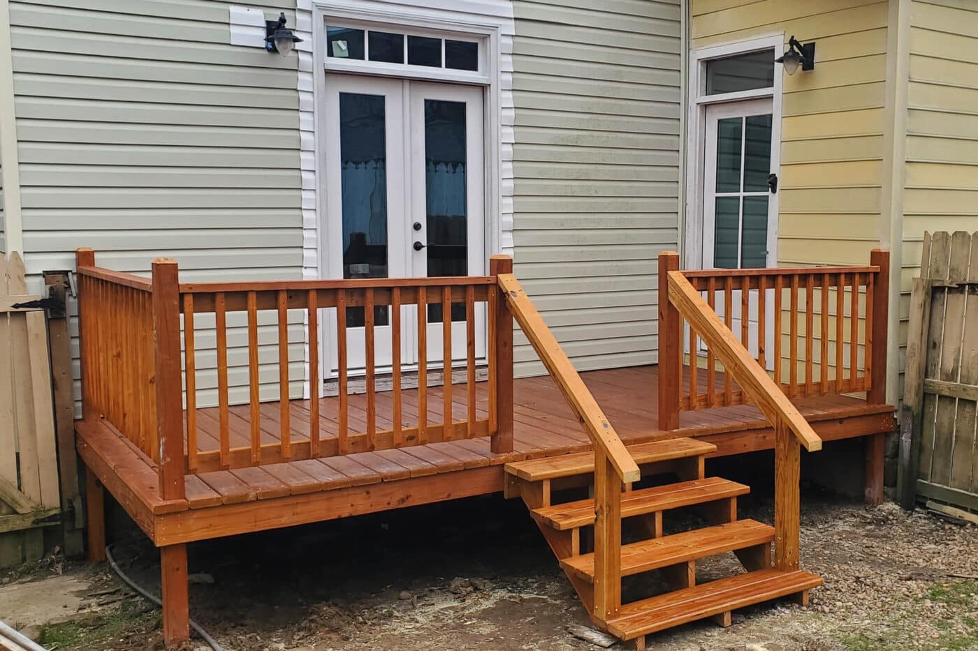 Cedar-stained 8x16 deck with railings and steps leading from a white double door in Springfield, Tennessee.