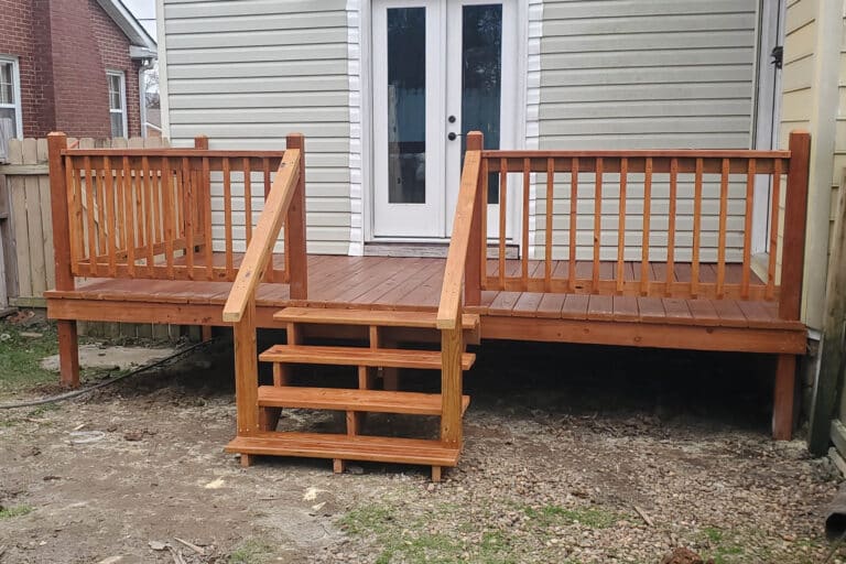 8x16 cedar-stained wooden deck with railings and steps attached to a beige house in Springfield, Tennessee.