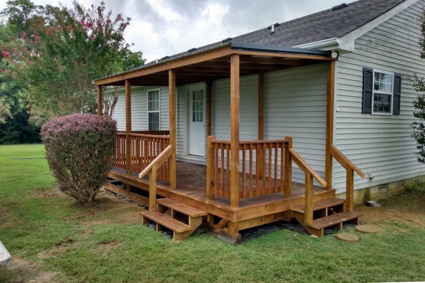 Horse porch attached to home in Tennessee with wooden railing, and stairs