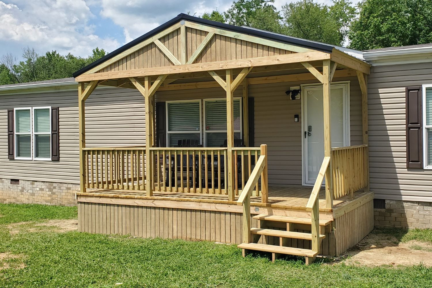 Mobile home porch for sale in Tennessee. Wooden structure with siding, steps, railings, and truss design