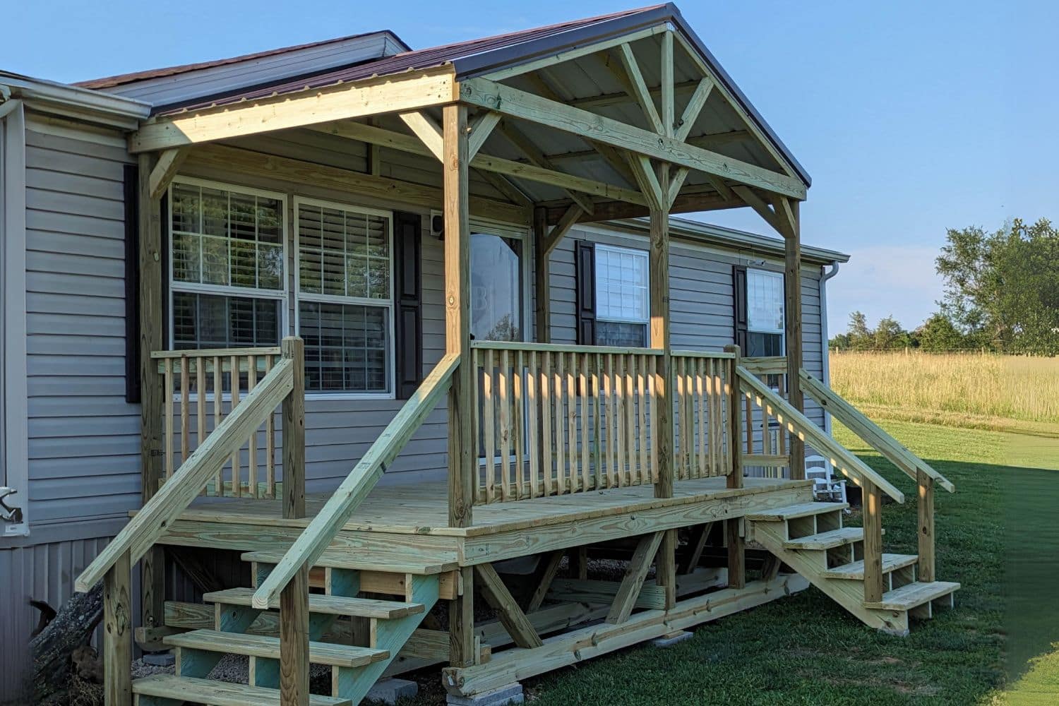 Mobile home porch in Kentucky with truss design on overhang and steps.