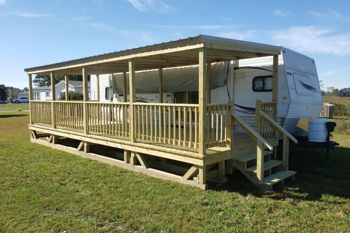 RV Deck with ceiling and steps attached to RV in grass
